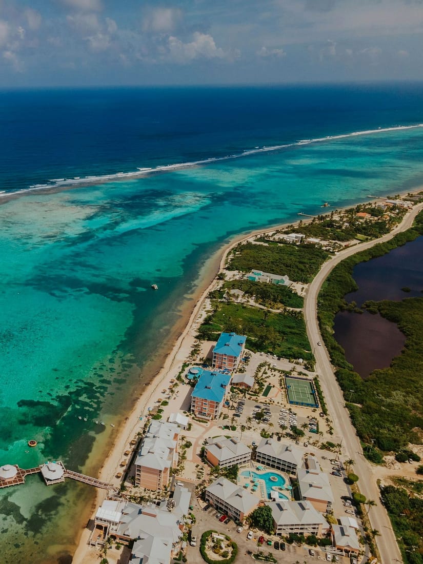 Aerial view of beachfront condos, the reef and the coast road at East End, Grand Cayman