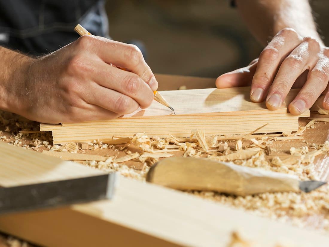 A carpenter marking a line on timber