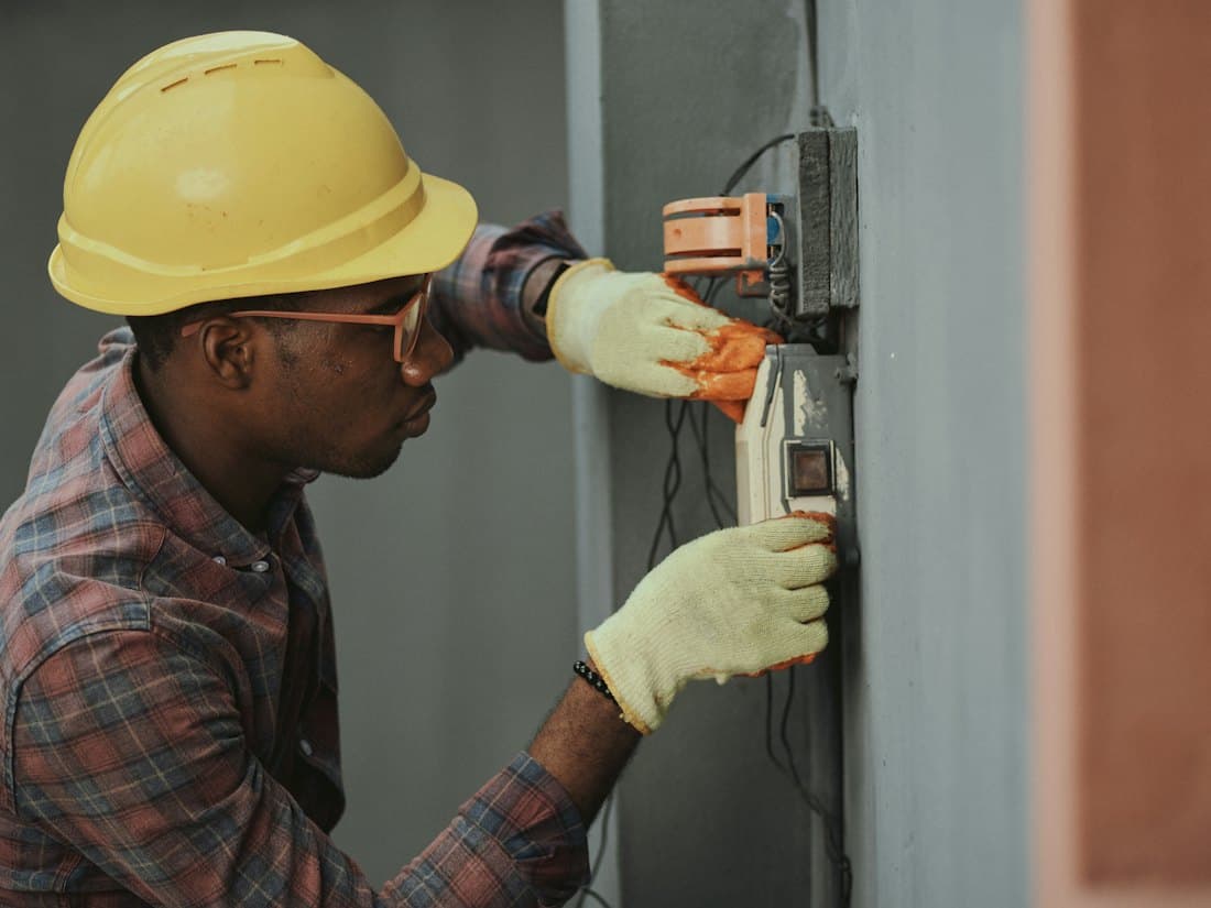 An electrician working at a wall panel