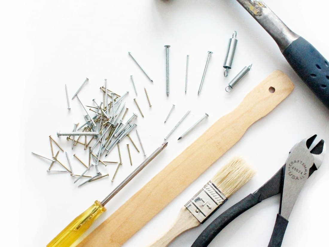 Hand tools and fixings laid out on a white surface